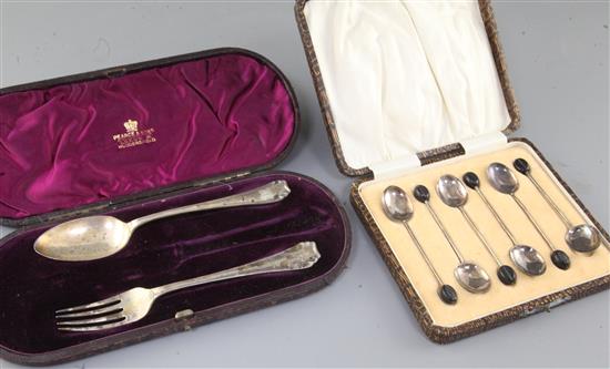 A cased set of six George V silver bean end coffee spoons and a cased christening spoon and fork (knife missing).